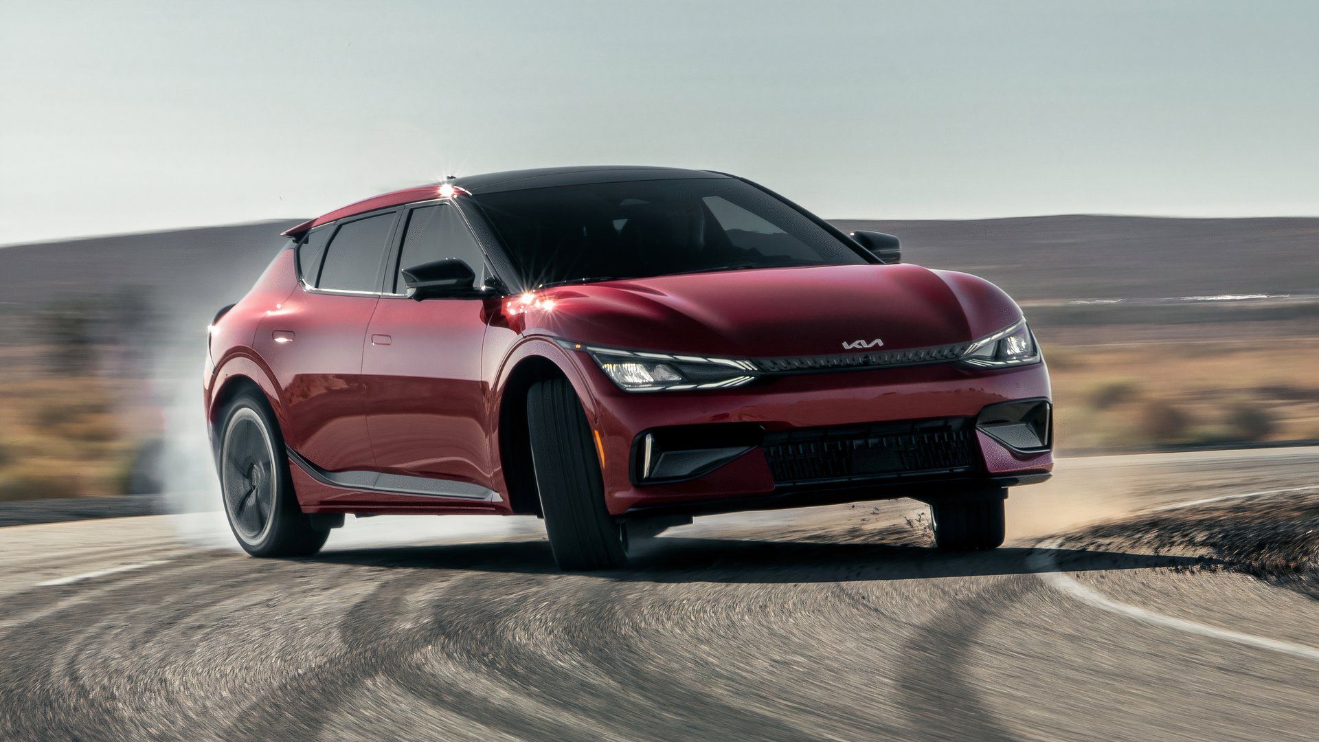 Foto de ação frontal 3/4 do Kia EV6 GT 2024 derrapando em uma pista de teste