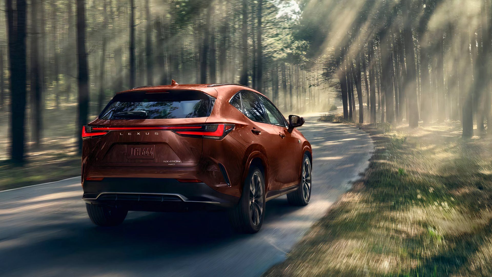 An orange 2025 Lexus NX Hybrid small hybrid SUV is driving. 