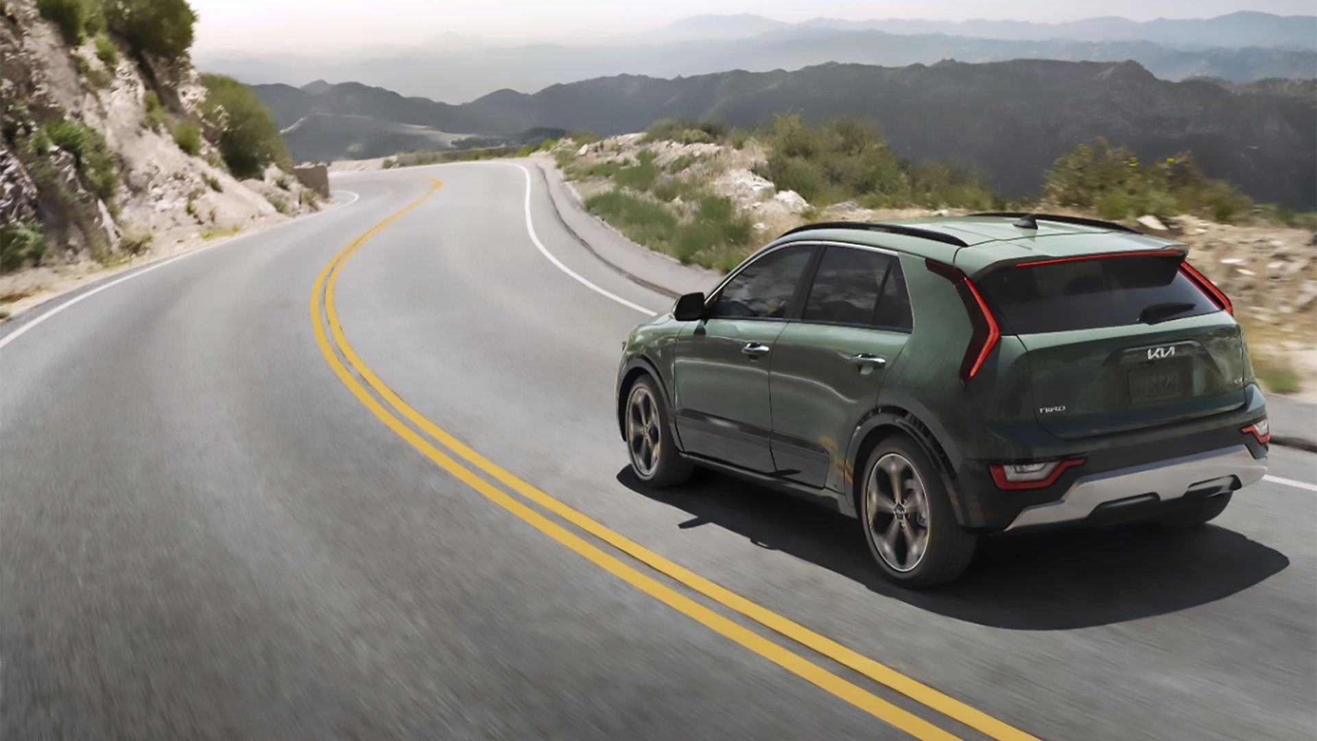 A Green 2024 Kia Niro Hybrid Driving