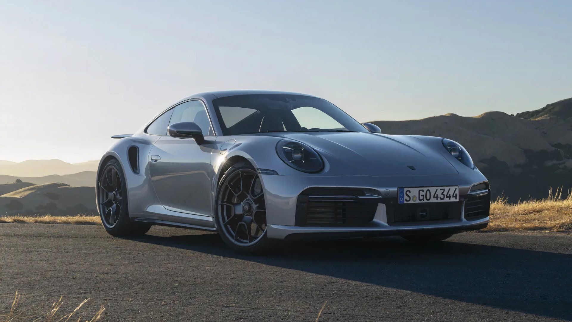 2024 Porsche 911 Turbo in silver posing in front of mountain range