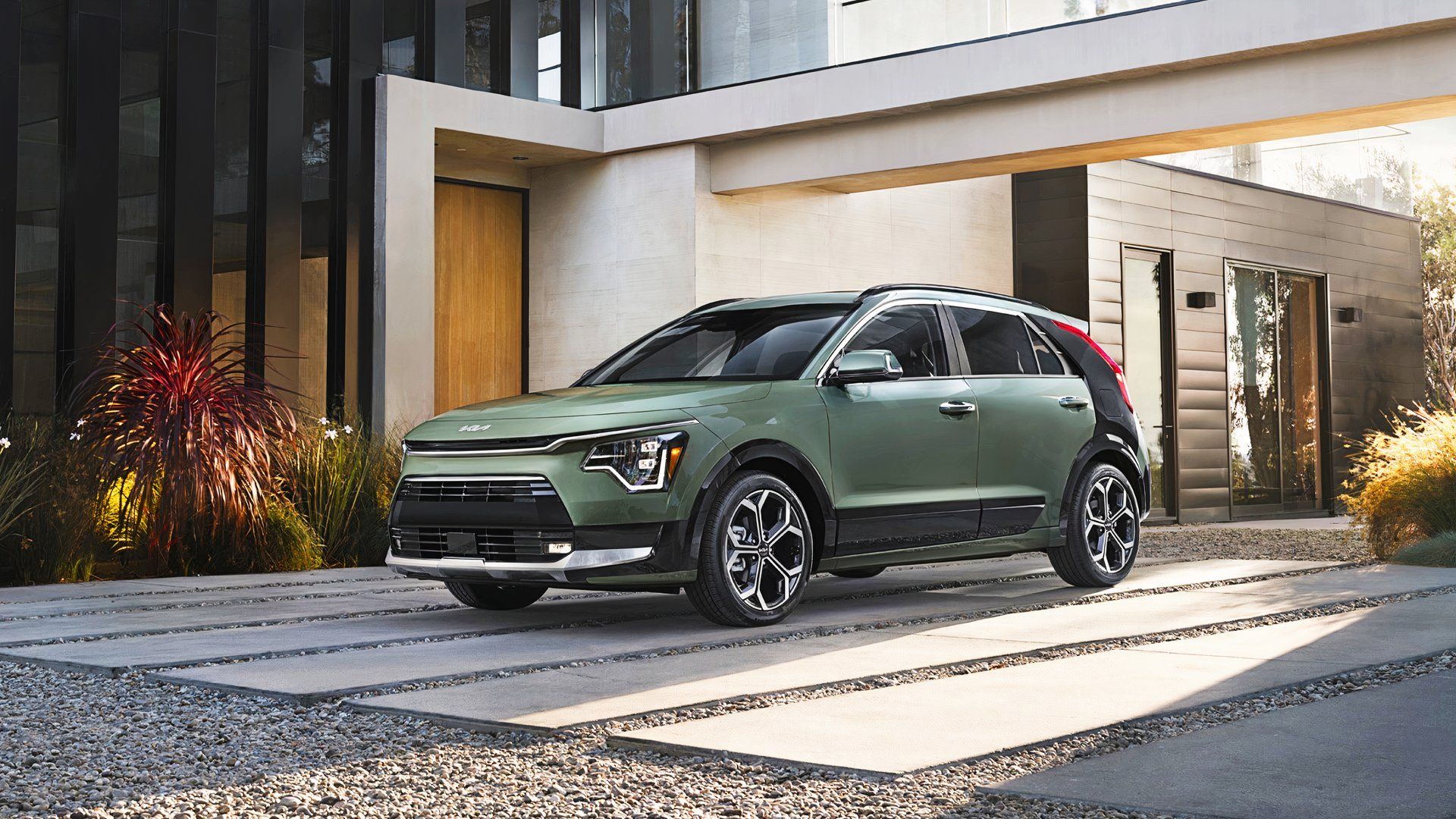 A green Kia Niro subcompact SUV is parked. 