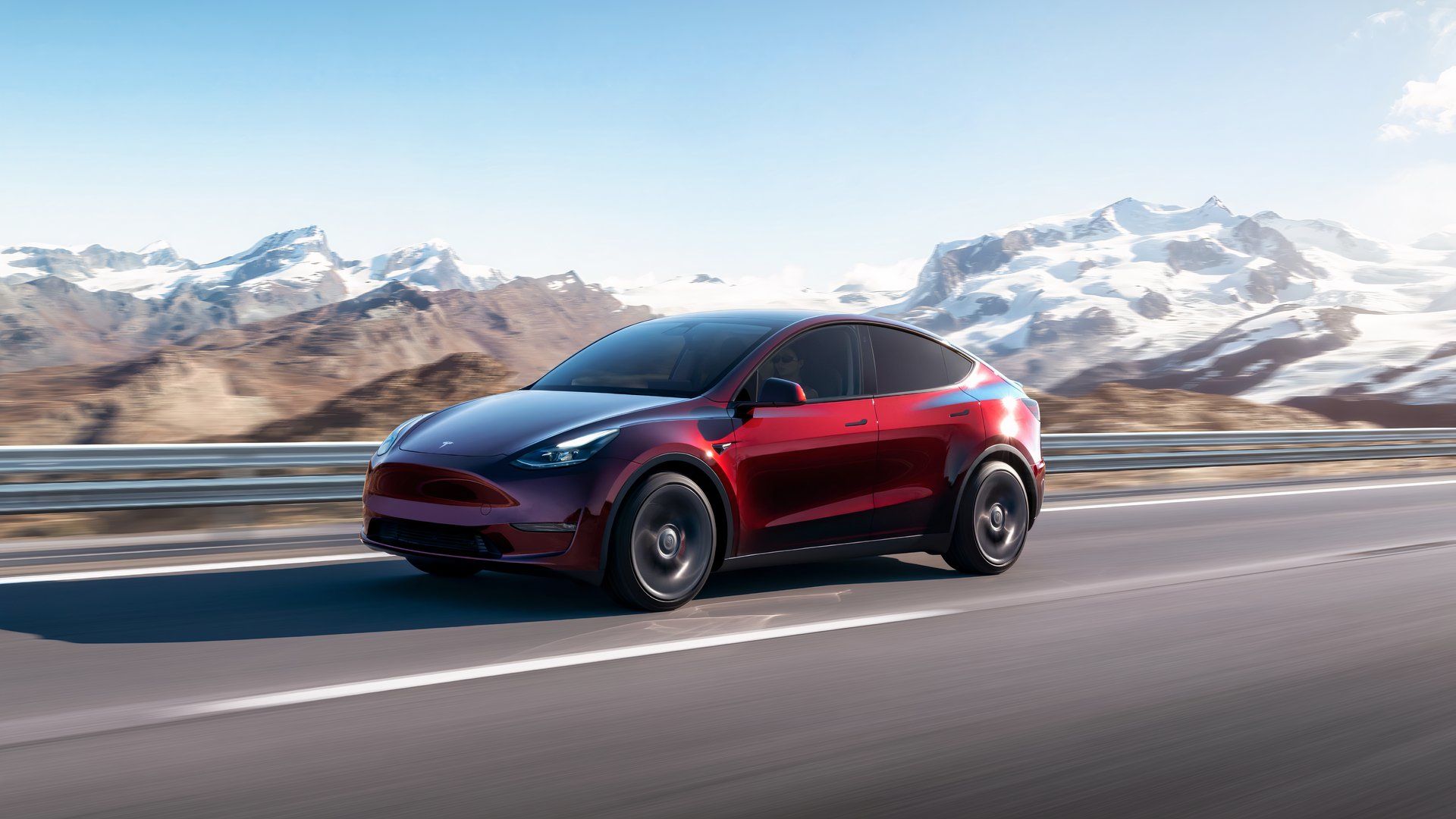 Um Tesla Model Y vermelho está dirigindo.