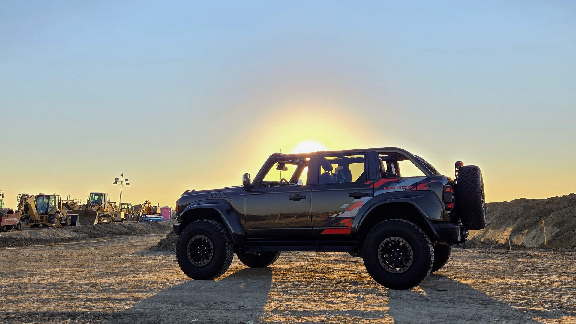 Vista lateral do SUV Ford Bronco Raptor 2024 ao pôr do sol-2