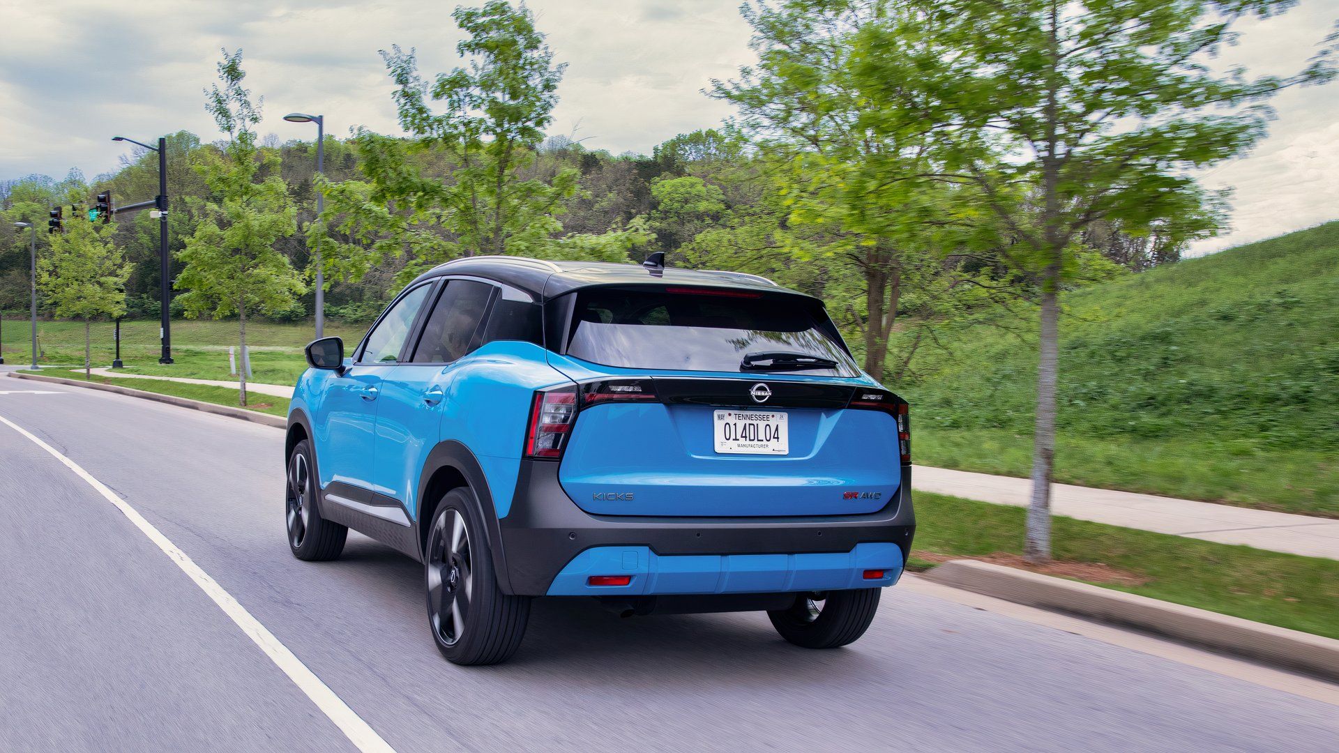 Vista traseira do Nissan Kicks 2025 dirigindo em uma rua 
