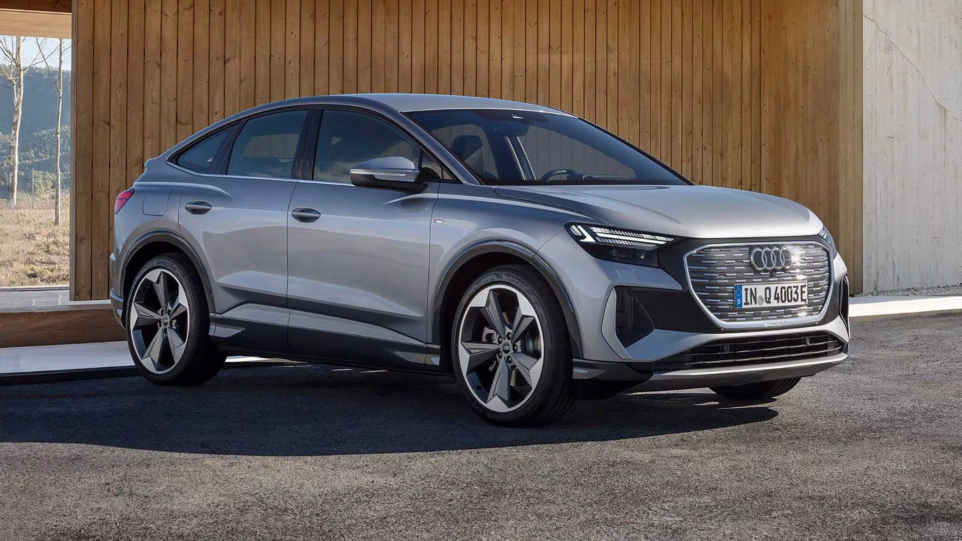 A front, right hand-side, three-quarter shot of a 2023 Audi Q8 e-tron Sportback parked outside a house