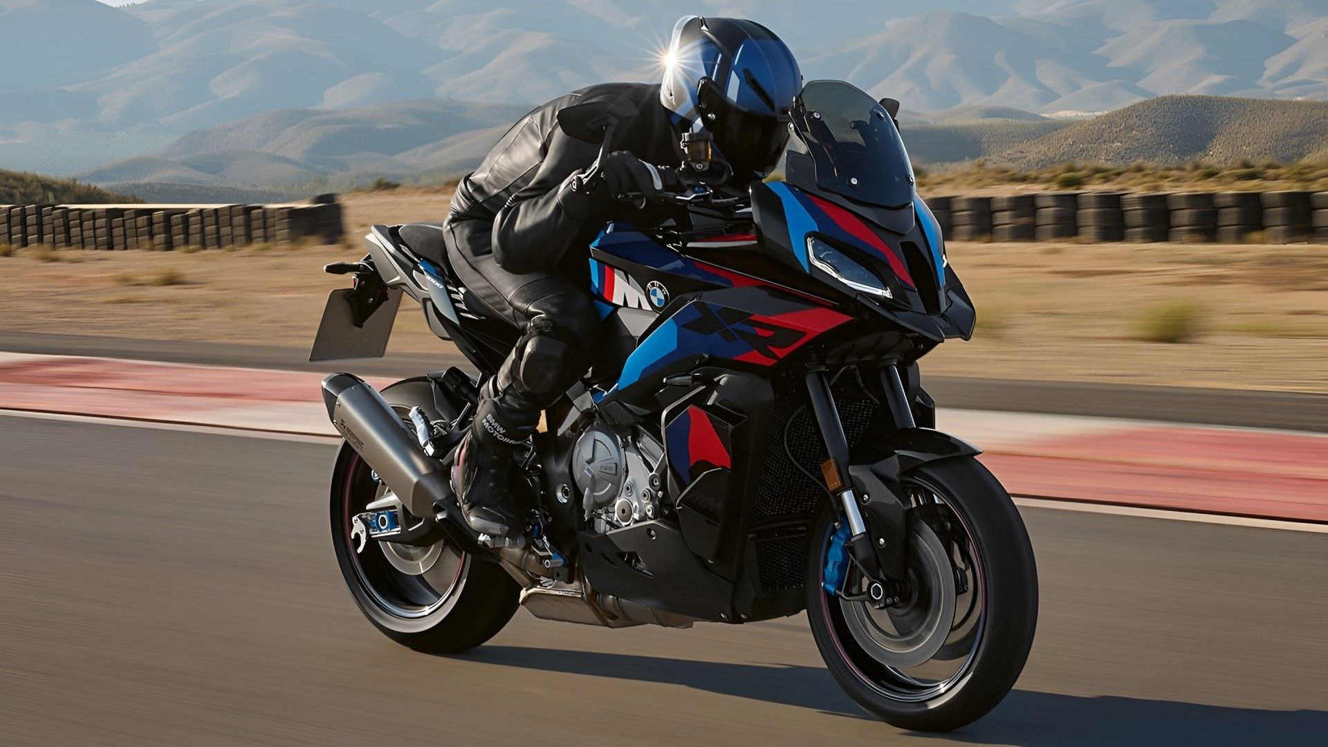 BMW M 1000 XR accelerating on a racetrack front third quarter view