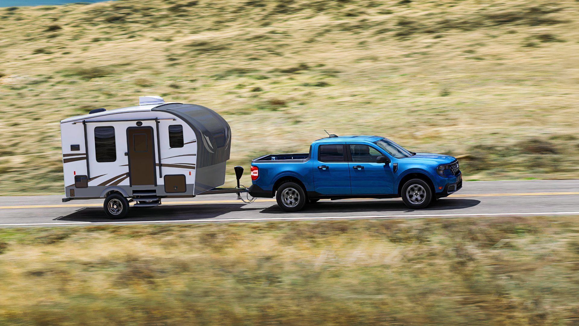 A blue 2025 Ford Maverick Hybrid is towing a trailer. 