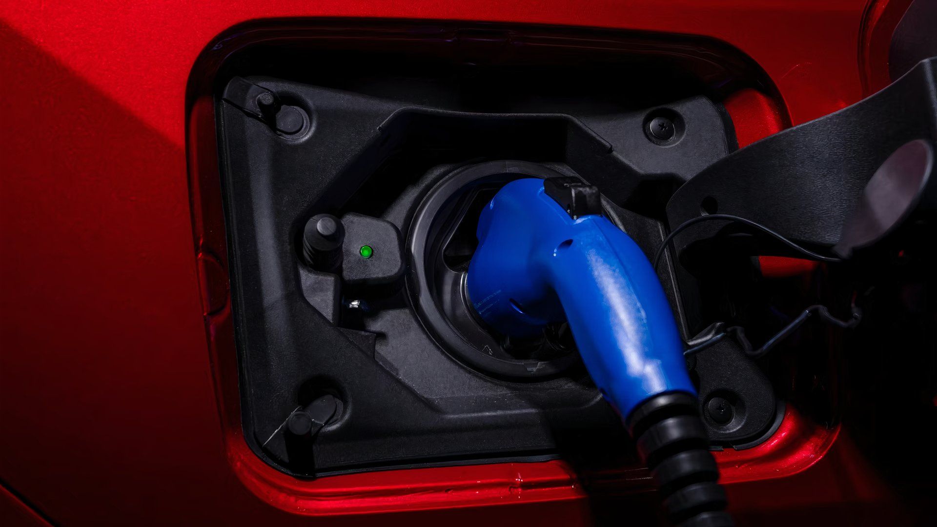 A red Toyota RAV4 Prime is charging.