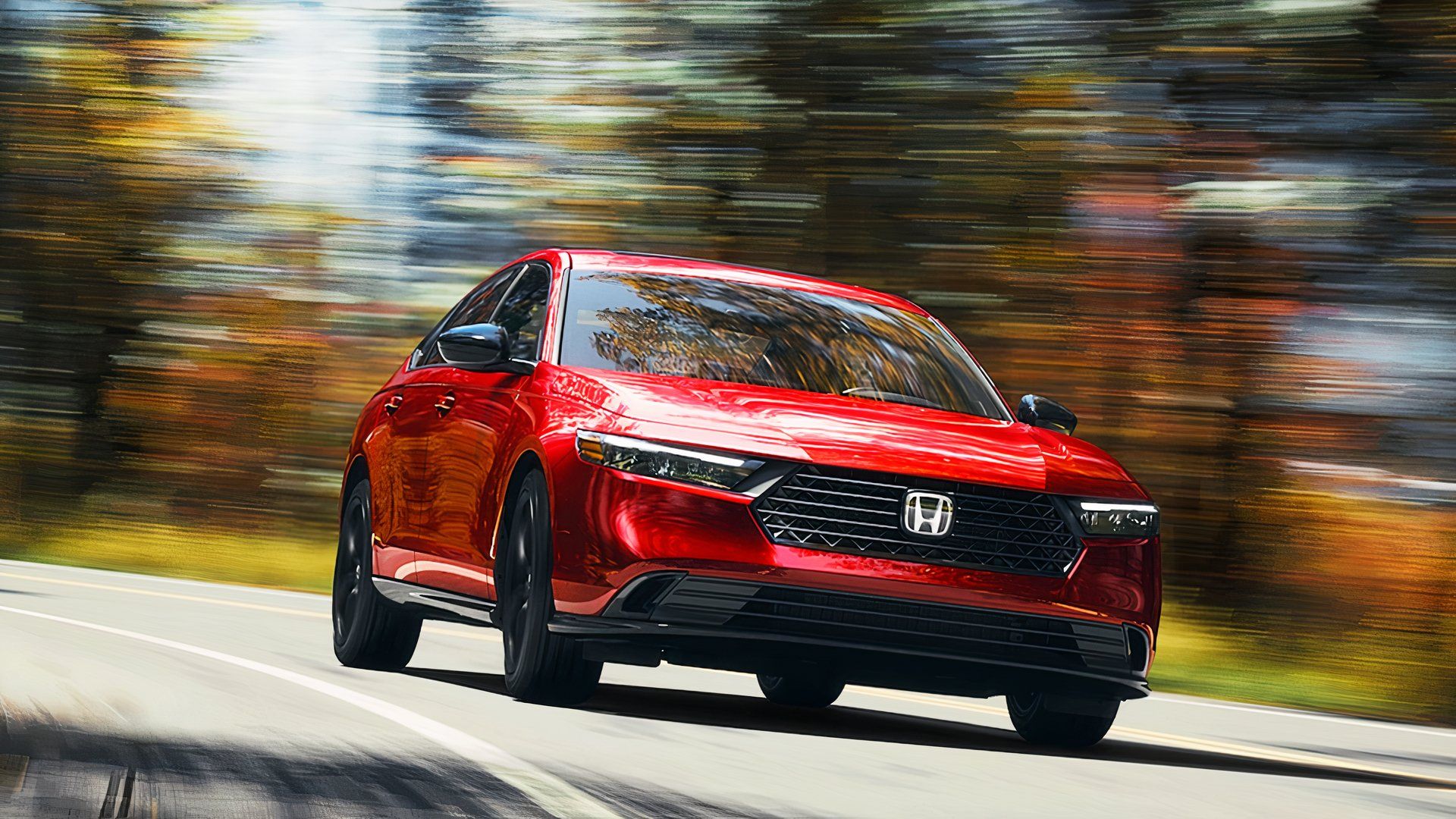 A red 2025 Honda Accord Hybrid midsize hybrid car is driving on the road. 