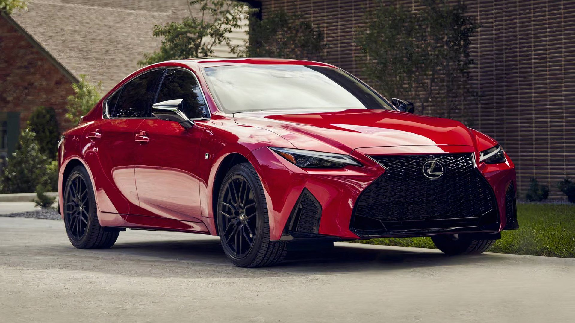 Lexus IS 500 F Sport Performance 2025 года красного цвета позирует перед домом