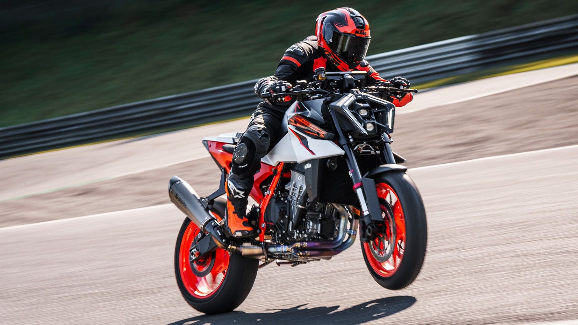 2025 KTM 990 Duke R popping a wheelie on racetrack hd wallpaper