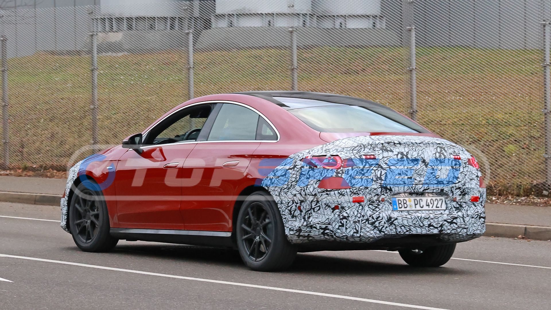 Rear three-quarters driving spy photo of a camouflaged 2026 Mercedes CLA-Class EV