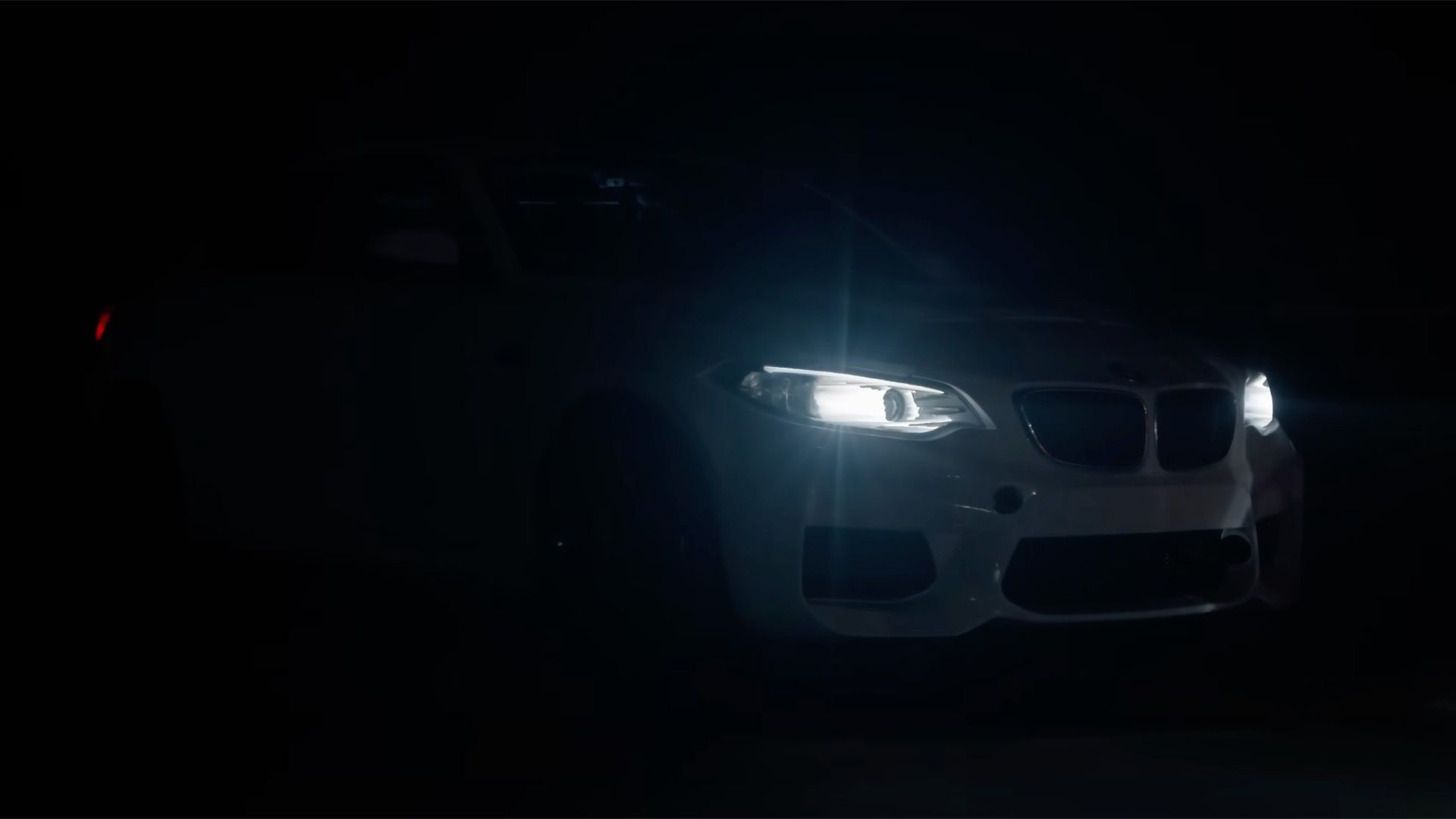 Photo of electric BMW M2 prototype headlights shining in the dark