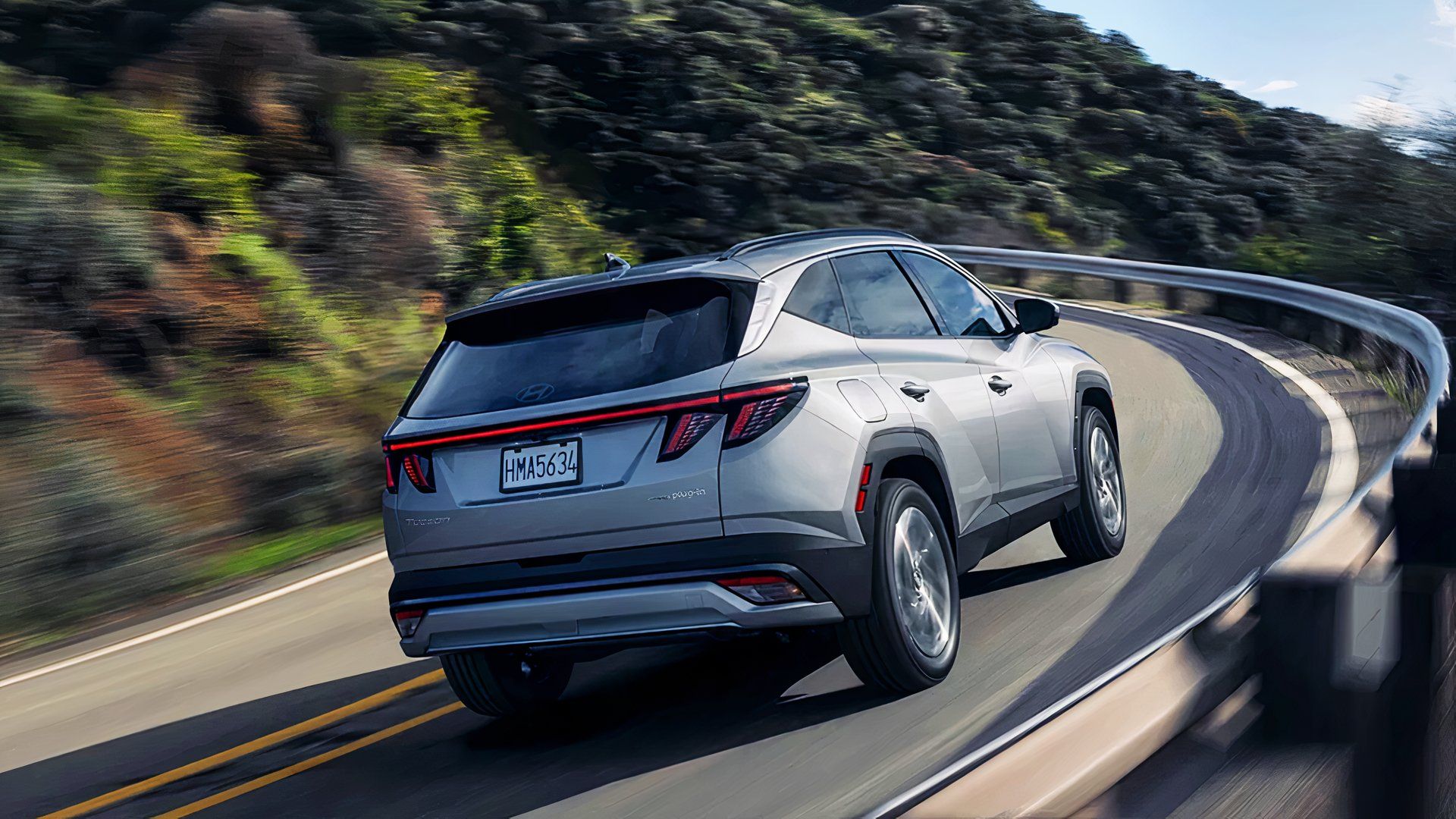 A gray 2025 Hyundai Tucson PHEV is driving. 