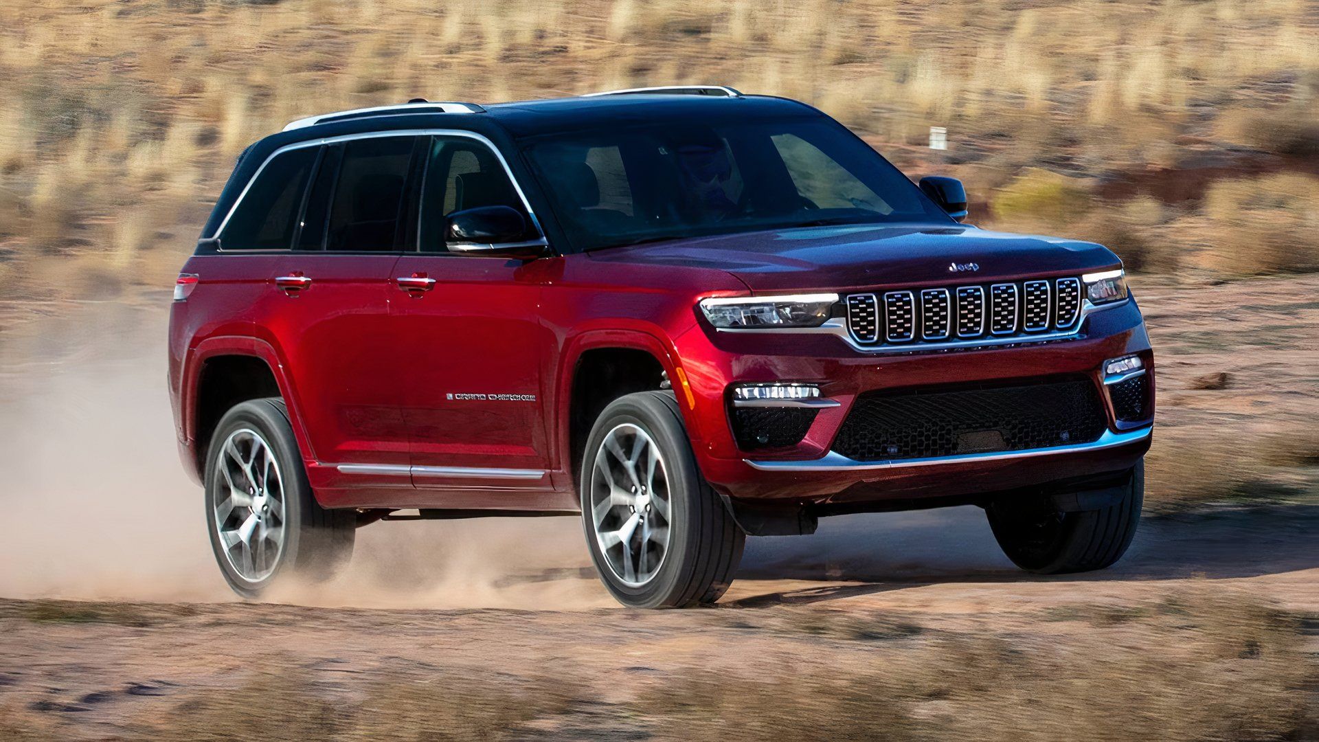 2025 Jeep Grand Cherokee Summit Reserve in red driving in desert