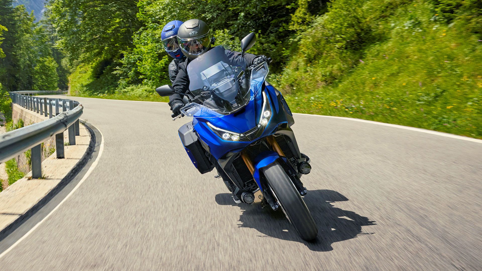 Rider and passenger on an accessorized 2025 Honda NT1100 DCT headon shot - European model shown