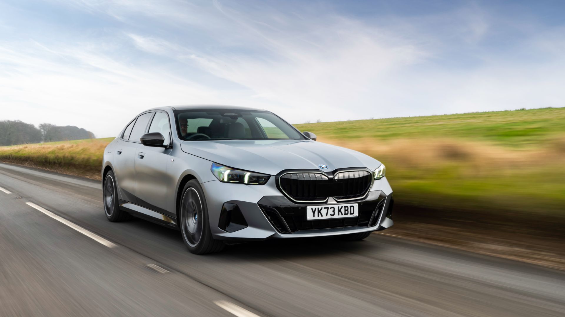 2025 BMW 550e Plug-In Hybrid Exterior Front Driving Down Road