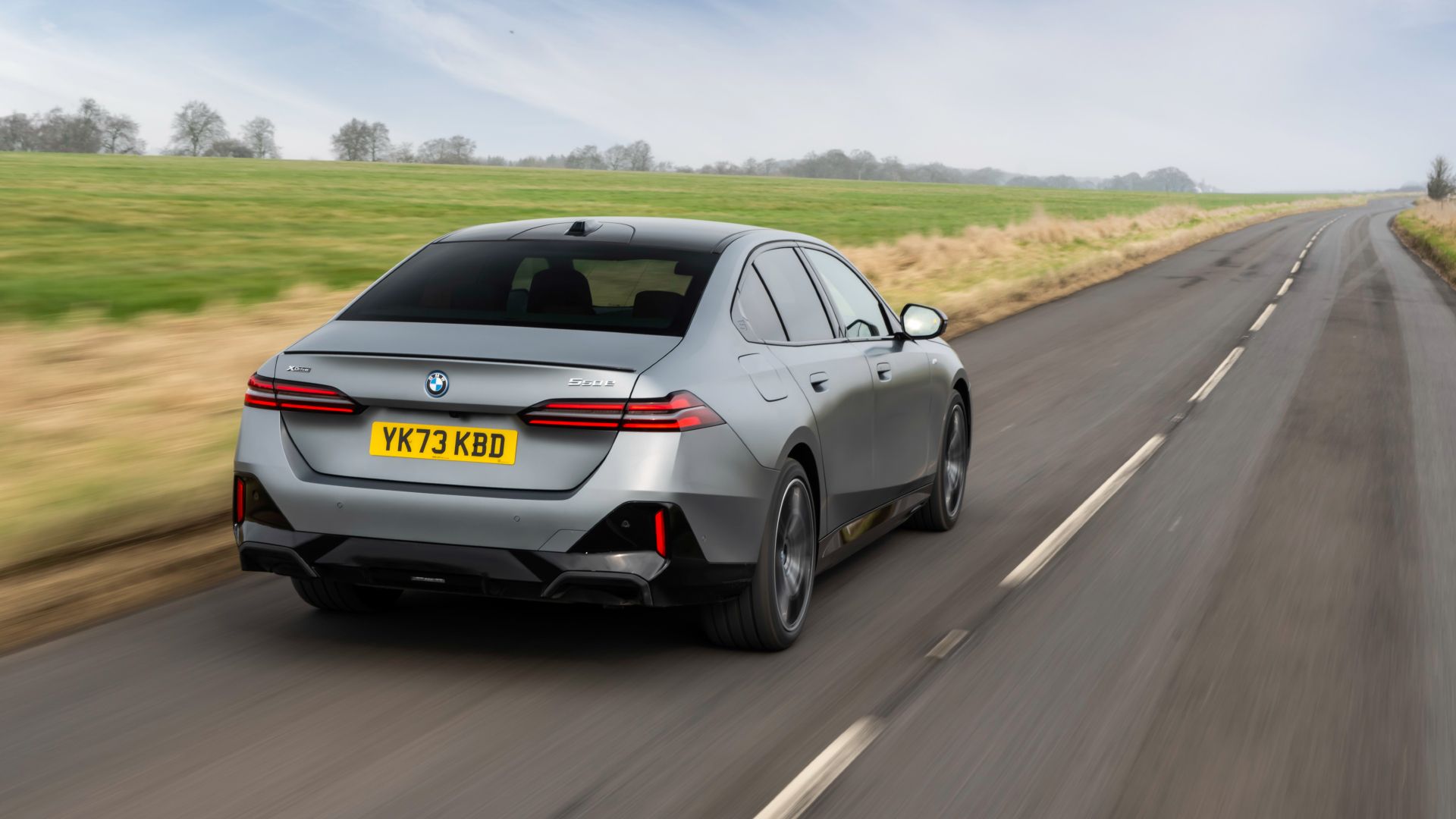 2025 BMW 550e Plug-In Hybrid Exterior Driving Down Road