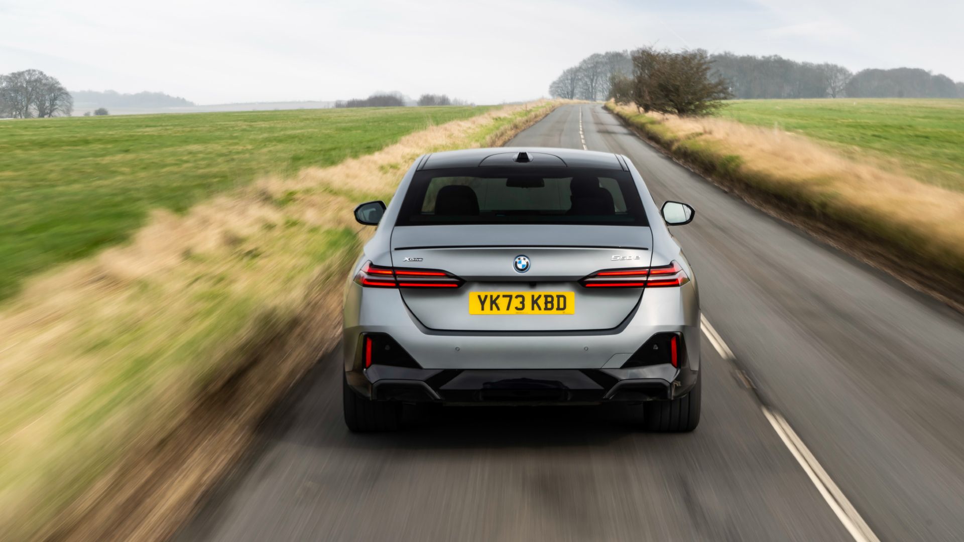 2025 BMW 550e Plug-In Hybrid Exterior Driving Down Road