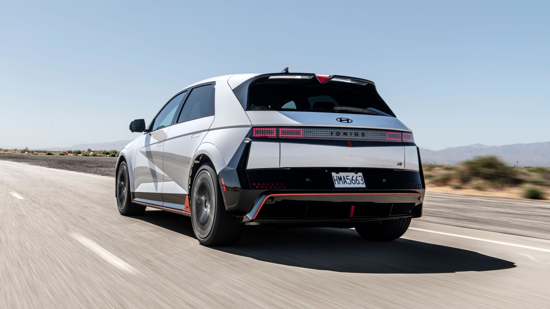 Rear three-quarters driving image of a white 2025 Hyundai Ioniq 5 N