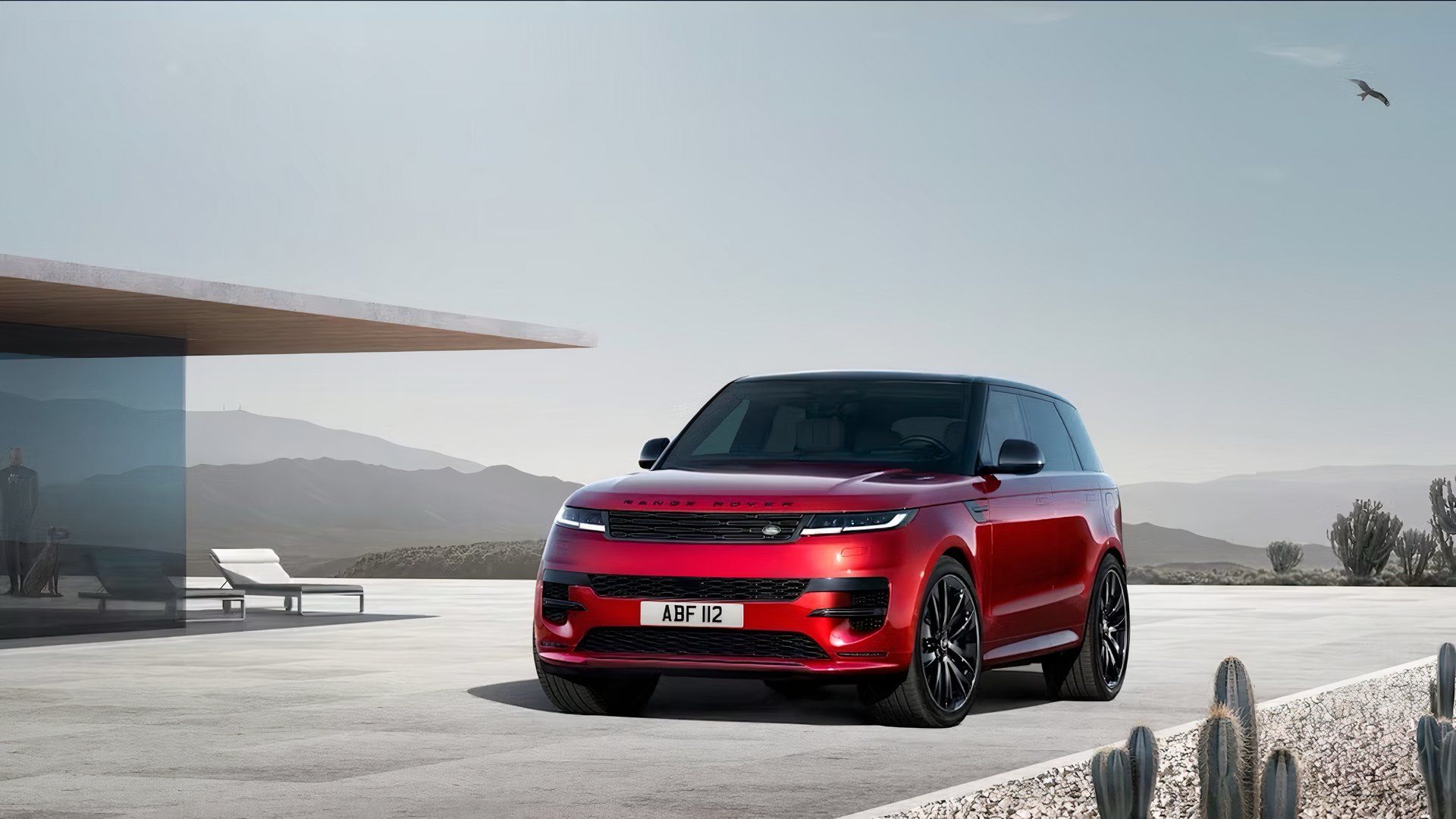 2025 Land Rover Range Rover Sport in red parked in front of house