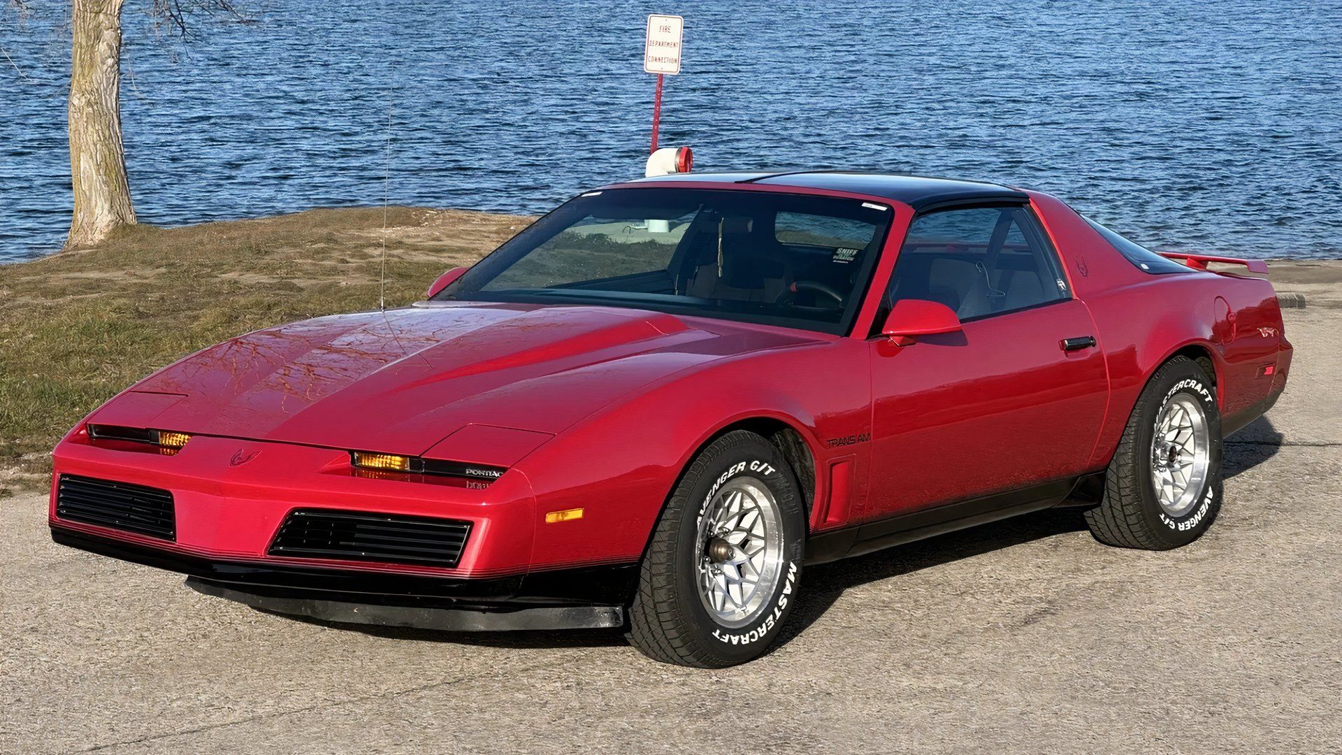 1982 Pontiac Firebird Trans Am in red parked by lake