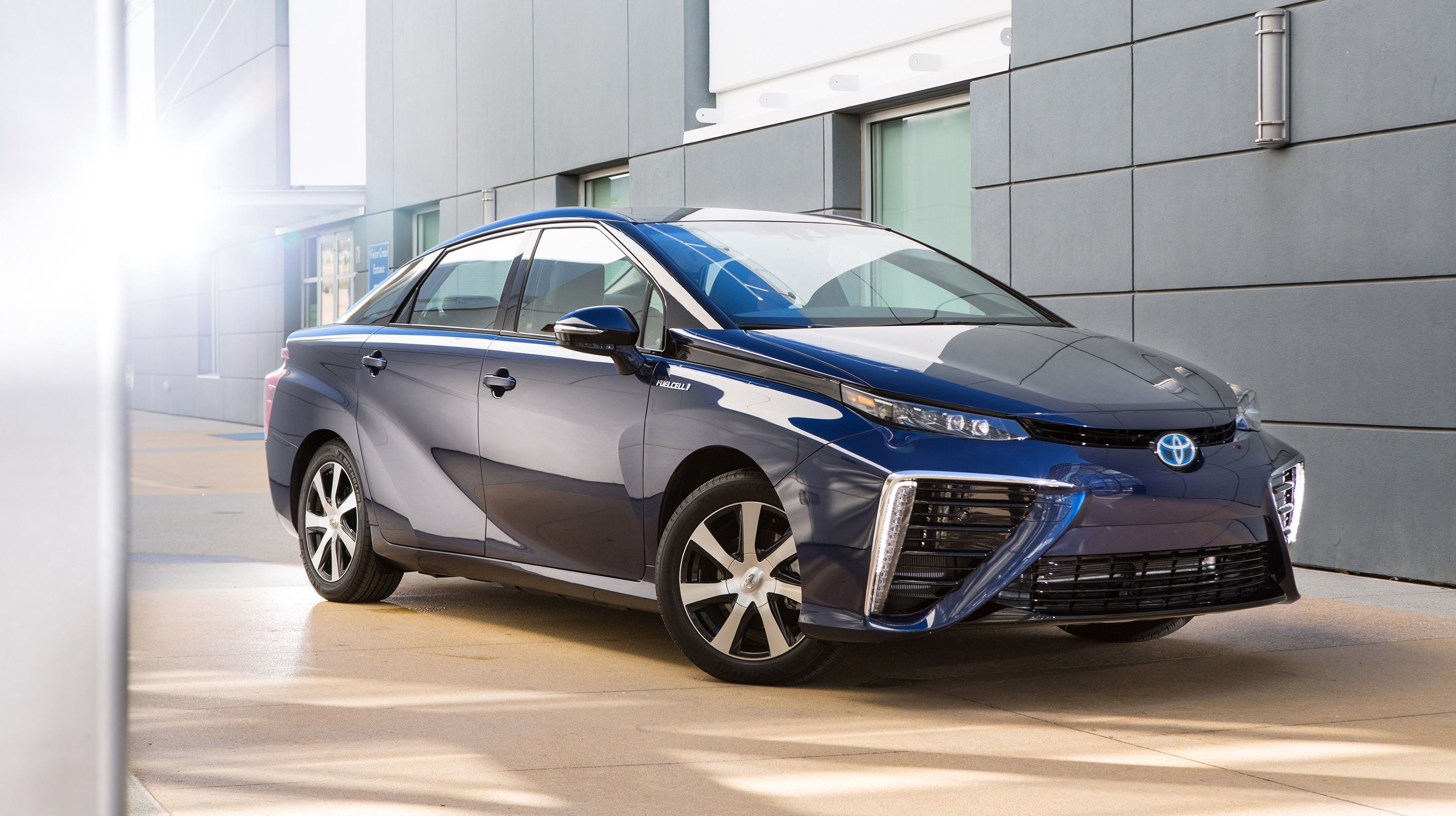 Blue Toyota Mirai parked next to a building