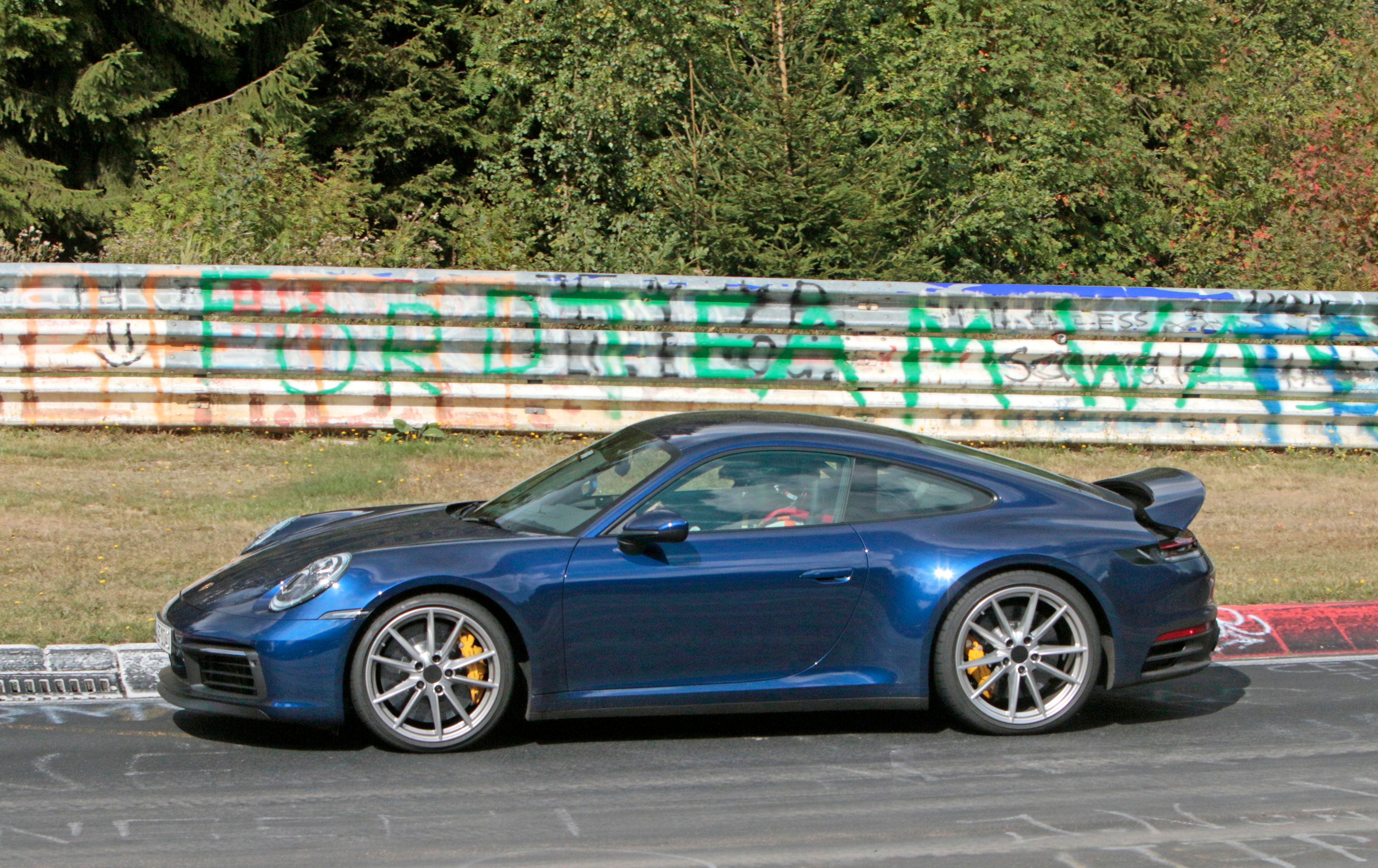 blue Porsche 911 992 Carrera driving