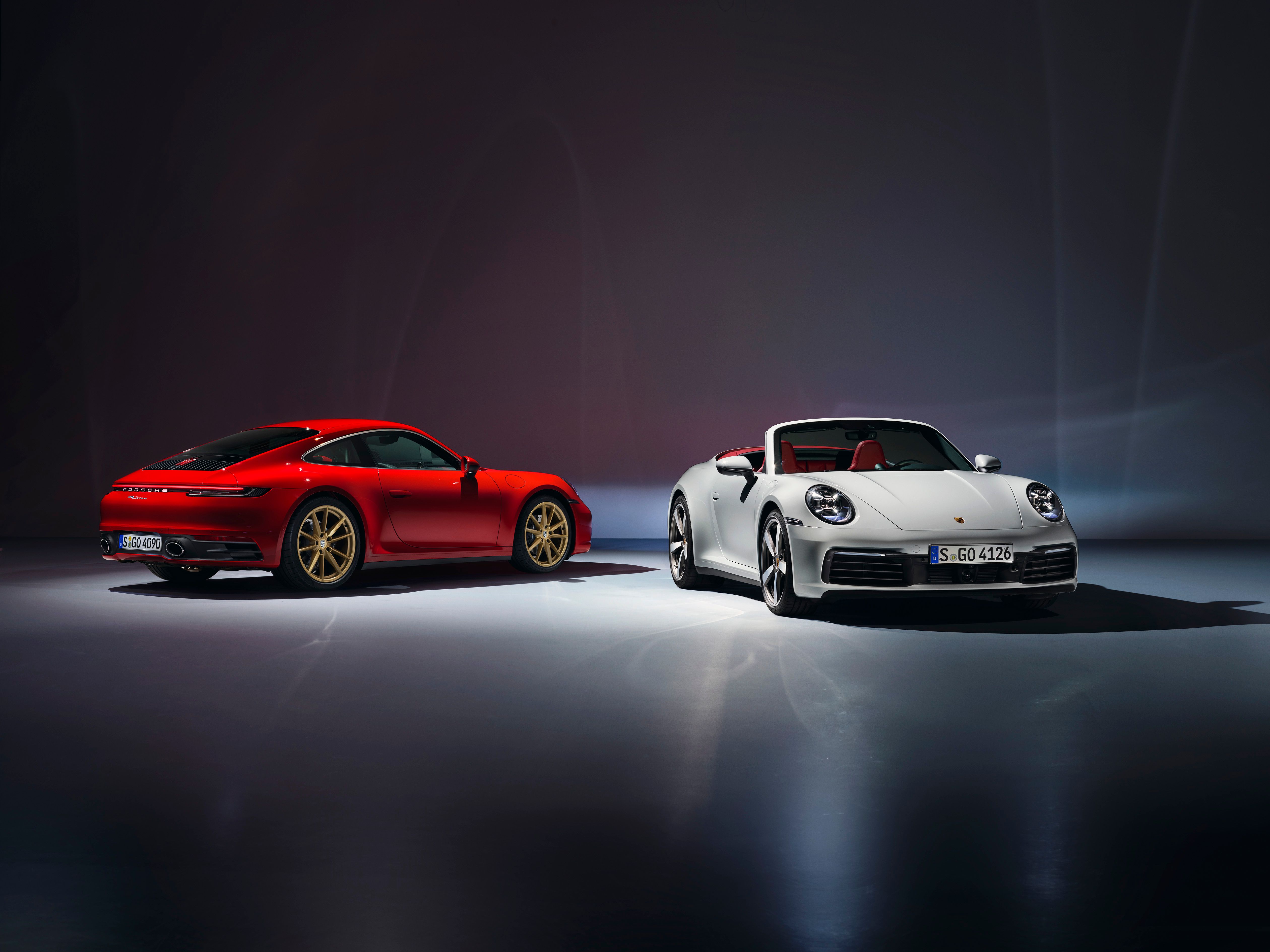 red Porsche 992 Carrera and white Porsche 911 Carrera Cabriolet 